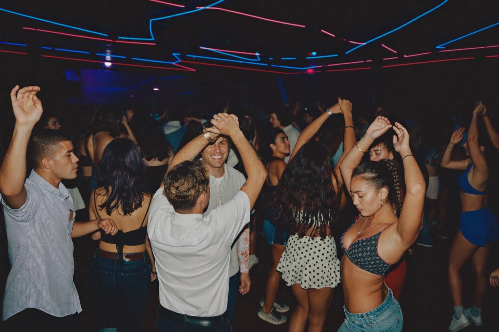 Three couples dancing different Latin styles in a moody club